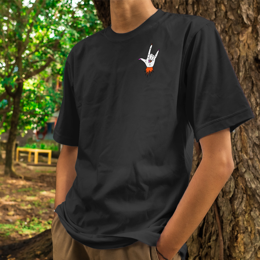 Person wearing a black t-shirt with a small rock-on hand emblem