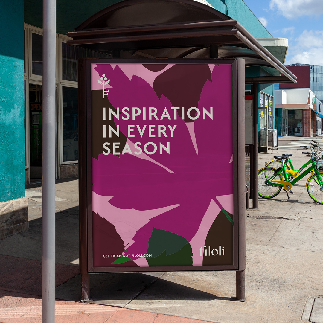 Bus shelter poster reading 'Inspiration in Every Season' on a purple leaf pattern
