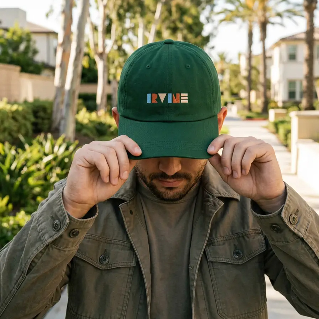 Person wearing a green Irvine baseball cap